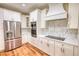 Modern kitchen with stainless steel appliances, white cabinetry, and hardwood flooring at 25 Oakbrook Ln, Covington, GA 30016