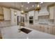 Modern kitchen featuring a large center island, marble backsplash, and stainless-steel appliances at 25 Oakbrook Ln, Covington, GA 30016