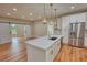 Bright kitchen featuring an island with a sink, modern appliances, and sliding barn doors at 25 Oakbrook Ln, Covington, GA 30016