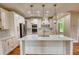 Bright, modern kitchen with white cabinetry, a large island, and stainless steel appliances at 25 Oakbrook Ln, Covington, GA 30016