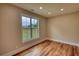 Bedroom with hardwood flooring, a large window, and views of the backyard at 25 Oakbrook Ln, Covington, GA 30016