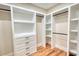 Custom walk-in closet featuring rods, drawers, shelving and wood floor at 25 Oakbrook Ln, Covington, GA 30016