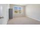 An uncluttered, neutral-toned bedroom features plush carpeting and a large window for natural light at 3399 In Bloom Way, Auburn, GA 30011