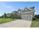 A charming two-story home with a gray brick exterior, well-maintained lawn, and a two car garage at 3399 In Bloom Way, Auburn, GA 30011
