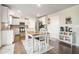 Eat-in kitchen features white cabinets, stainless steel appliances, dark hardwood floors, and granite countertops at 3399 In Bloom Way, Auburn, GA 30011