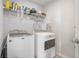Functional laundry room with modern washer and dryer units, plus storage shelves for convenience and organization at 3399 In Bloom Way, Auburn, GA 30011