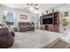 Large living room with a built-in entertainment center, plush seating, and windows at 3399 In Bloom Way, Auburn, GA 30011