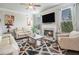 Comfortable living room with fireplace, neutral tones, and large windows providing ample natural light at 3399 In Bloom Way, Auburn, GA 30011