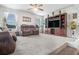 Spacious living room featuring plush leather sofas, ceiling fan, and a large entertainment center at 3399 In Bloom Way, Auburn, GA 30011