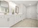 Bright bathroom featuring double sinks, white cabinetry, and tile flooring at 1606 Chancery Ln, Lithia Springs, GA 30122