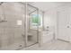 Bright bathroom featuring a glass-enclosed shower and soaking tub at 1606 Chancery Ln, Lithia Springs, GA 30122