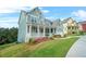 Charming two-story home featuring a wide porch, manicured lawn, and colorful flower beds at 1606 Chancery Ln, Lithia Springs, GA 30122