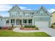 Inviting two-story home featuring a charming front porch, well-manicured lawn, and attached two-car garage at 1606 Chancery Ln, Lithia Springs, GA 30122