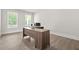 Well-lit home office space featuring a large desk, two windows, and sleek flooring for a professional setting at 1606 Chancery Ln, Lithia Springs, GA 30122