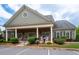 Clubhouse exterior featuring stone accents, covered porch, landscaping, and rocking chairs at 2061 Grove Field Lane #13, Marietta, GA 30064