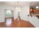 Dining room showcasing hardwood floors, decorative trim, modern chandelier and access to sunroom at 2061 Grove Field Lane #13, Marietta, GA 30064