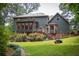 The home's backyard has a sunroom, wooden deck, verdant lawn, and landscape garden at 2646 Kinnett Sw Dr, Lilburn, GA 30047