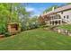 Picturesque backyard featuring a playhouse, lush lawn, mature trees, and terraced landscaping at 3925 Sheldon Ne Dr, Atlanta, GA 30342