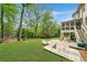 Expansive backyard with lush lawn, stone patio, outdoor kitchen, and mature trees, perfect for outdoor living at 3925 Sheldon Ne Dr, Atlanta, GA 30342