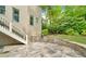 Spacious stone patio with stairs that lead to a lush green yard, accented by mature trees and landscaping at 3925 Sheldon Ne Dr, Atlanta, GA 30342