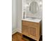 Elegant bathroom with a vanity featuring a marble countertop, wooden cabinet, and octagon mirror with decorative sconces at 3925 Sheldon Ne Dr, Atlanta, GA 30342
