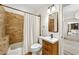Cozy bathroom with updated vanity and mirror, and a tub and shower combo featuring unique brick-like tile at 3925 Sheldon Ne Dr, Atlanta, GA 30342