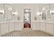 Elegant bathroom featuring dual vanities, decorative mirrors, sconces, and geometric tile flooring at 3925 Sheldon Ne Dr, Atlanta, GA 30342
