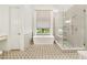 Luxurious bathroom featuring a soaking tub, glass-enclosed shower, and geometric tile flooring at 3925 Sheldon Ne Dr, Atlanta, GA 30342