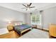 Stylish bedroom featuring a bed with a gray comforter, a window, and hardwood floors at 3925 Sheldon Ne Dr, Atlanta, GA 30342