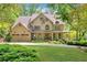 Charming two-story traditional home featuring a three-car garage and a well-manicured front yard at 3925 Sheldon Ne Dr, Atlanta, GA 30342