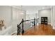 Hallway with hardwood floors, white trim, black railing, gray walls, and modern light fixtures at 3925 Sheldon Ne Dr, Atlanta, GA 30342