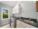 Laundry room featuring stainless steel washer and dryer and white cabinets with a black countertop at 3925 Sheldon Ne Dr, Atlanta, GA 30342