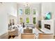 Open-concept living room featuring a modern fireplace, hardwood floors, and large picture windows at 3925 Sheldon Ne Dr, Atlanta, GA 30342