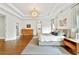Spacious main bedroom featuring tray ceilings, hardwood floors, and contemporary chandelier at 3925 Sheldon Ne Dr, Atlanta, GA 30342