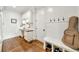 Mudroom with hardwood floors, white walls, storage bench, desk and cabinets with a guitar case against the wall at 3925 Sheldon Ne Dr, Atlanta, GA 30342