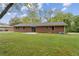 Back exterior view of a brick home with a patio and lush green lawn at 509 Woodland Ln, Lawrenceville, GA 30043
