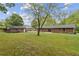 Back exterior view of a brick home with a patio and lush green lawn at 509 Woodland Ln, Lawrenceville, GA 30043