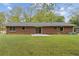 Back exterior view of a brick home with a patio and lush green lawn at 509 Woodland Ln, Lawrenceville, GA 30043
