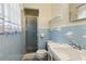 Blue tiled bathroom with a shower and neutral fixtures at 509 Woodland Ln, Lawrenceville, GA 30043