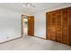 Bedroom with light carpet, ceiling fan, and a closet with trees outside at 509 Woodland Ln, Lawrenceville, GA 30043
