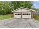 Detached two-car garage featuring white doors, brick exterior and an expansive paved driveway at 509 Woodland Ln, Lawrenceville, GA 30043