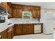 Kitchen with wood cabinets, white countertop, white appliances, and window above sink at 509 Woodland Ln, Lawrenceville, GA 30043