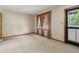 Cozy living room featuring neutral carpet, a window with curtains, and an elegant glass storm door at 509 Woodland Ln, Lawrenceville, GA 30043