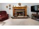 Close-up of the living room's stone fireplace with a mantel and lit fire at 569 Hale Mountain Ct, Hiram, GA 30141