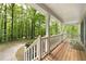 Inviting front porch with wooden flooring, white railings, and views of the surrounding greenery at 569 Hale Mountain Ct, Hiram, GA 30141