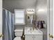 A cozy bathroom featuring a sink, vanity, mirror, toilet, and a shower with a blue curtain at 115 Blue Ridge Trl, Powder Springs, GA 30127
