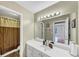 Well-lit bathroom features a large vanity mirror, white cabinetry, and shower-tub combo at 115 Blue Ridge Trl, Powder Springs, GA 30127
