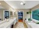 Bathroom with double sinks, soaking tub, and an inviting view into the main bedroom at 115 Blue Ridge Trl, Powder Springs, GA 30127