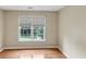 Bright bedroom features a large window, neutral walls, and hardwood flooring at 115 Blue Ridge Trl, Powder Springs, GA 30127