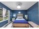 Stylish bedroom with a tufted headboard bed, accent lighting, and a window with natural light at 115 Blue Ridge Trl, Powder Springs, GA 30127